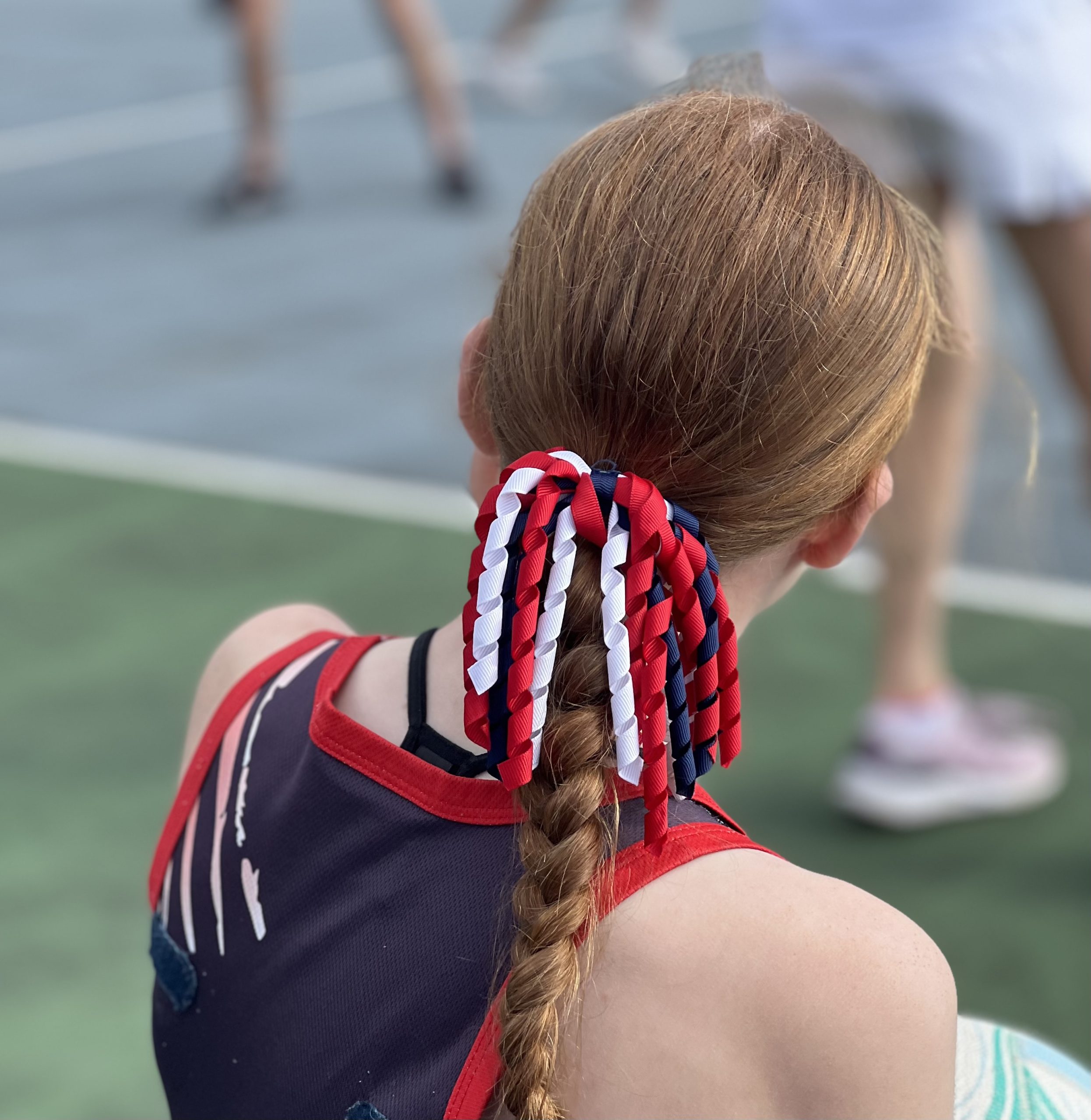 KNA player photographed from behind, wearing red, white and blue ribbons.